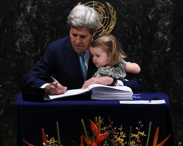 美国国务卿约翰·克里 (John Kerry) 抱着他的孙女在《巴黎协定》的签署仪式上